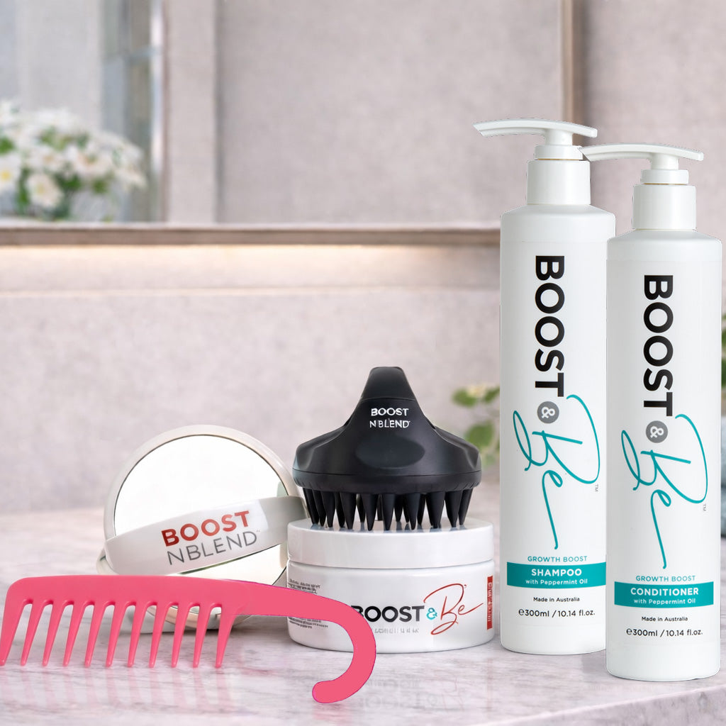 Boost & Be Hair care products Growth Boost Shampoo and Conditioner, and hair mask, including a scalp massager, mirror and wide toothed comb on a bathroom counter